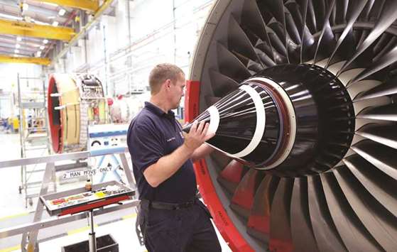 An employee fits the nose cone to a Trent 700 aircraft engine on the production line at the Rolls-Royce Holdings factory in Derby. Rolls-Royce plans to remove 10% of the workforce, targeting duplication in corporate, administration and management roles to try to save u00a3400mn ($536mn) a year by 2020. Two thirds of the job cuts will fall in Britain.