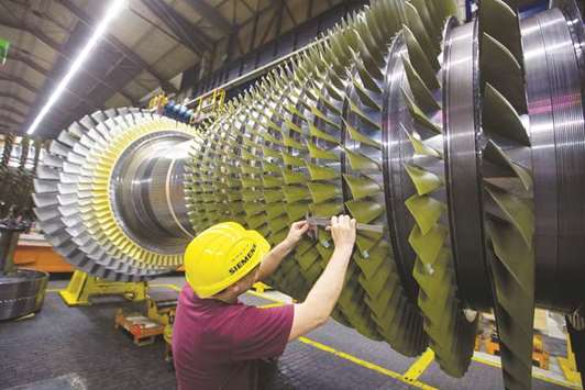 An employee takes blade measurements on a F-class turbine on the assembly line of Siemens gas turbine factory in Berlin.  Siemens is looking at all possibilities, such as a combination with a rival, for what was once a flagship operation within the power and gas division, sources say