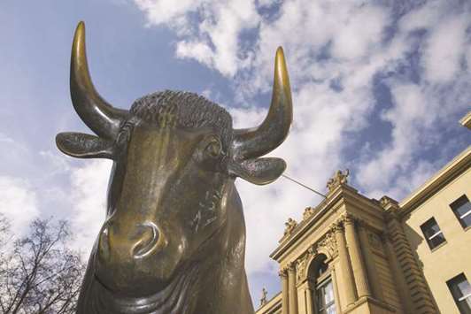 A statue of a bull is seen standing outside the entrance to the Frankfurt Stock Exchange. The DAX 30 closed 1.7% up at 13,107.10 points yesterday.