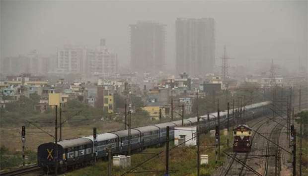 A train passes by as dust covers the skyline on the outskirts of New Delhi on Thursday.