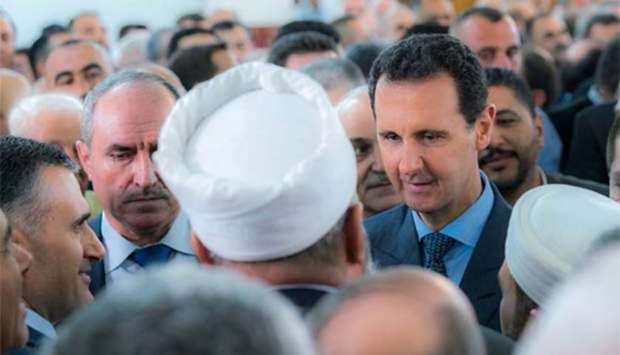 Syria's President Bashar al-Assad greets his supporters during Eid al-Fitr prayers at a mosque in Tartous on Friday.