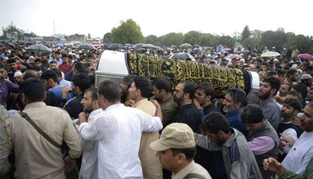 People carry the coffin of Shujaat Bukhari, the slain editor-in-chief of the Srinagar-based newspaper Rising Kashmir, during a funeral procession at Kreeri, some 40 kms north of Srinagar on Friday.