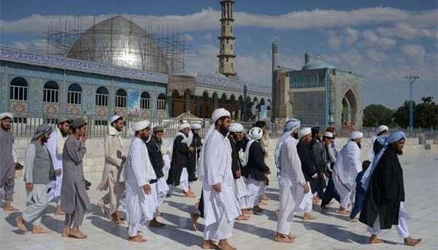Afghans walk to offer Eid al-Fitr prayers in Mazar-i- Sharif on Friday.
