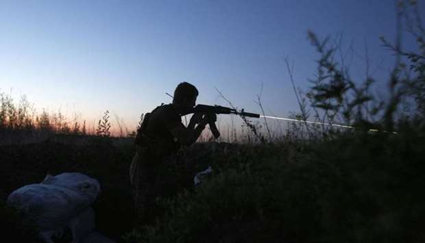 A Ukrainian serviceman fires his gun in the direction of Russia-backed separatists during night combat near the southeastern city of Mariupol late on June 10, 2018