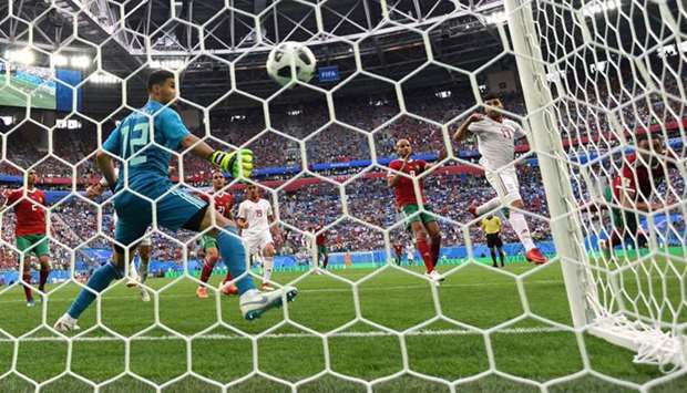 Morocco's Aziz Bouhaddouz scores an own goal past Munir Mohamedi for Iran's first goal. Reuters