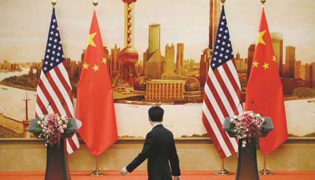 An official walks past US and Chinese flags placed for a joint news conference by US Secretary of State Mike Pompeo and Chinese Foreign Minister Wang Yi at the Great Hall of the People in Beijing on June 14. US President Donald Trump said in a statement yesterday that a 25% tariff would be imposed on a list of strategically important imports from China.