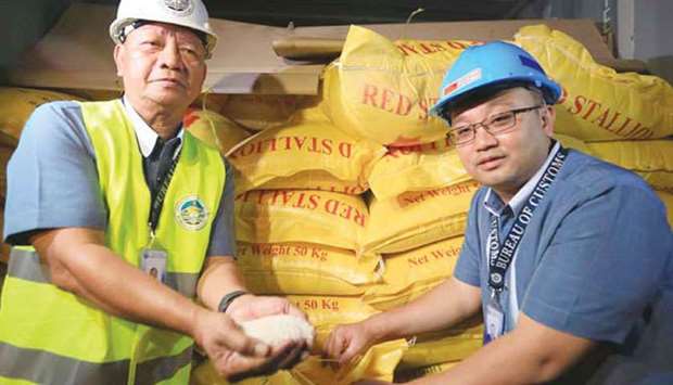 Customs Commissioner Isidro Lapena presents a container with sacks of smuggled Thailand white rice, which were imported from Vietnam.