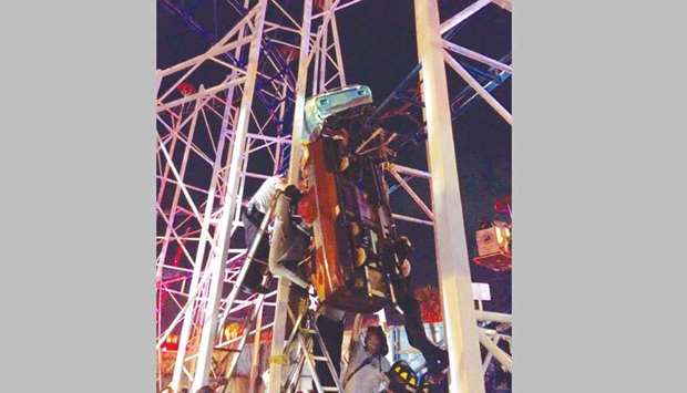 This picture issued by the Daytona Beach fire department shows firefighters work to rescue two roller coaster riders after their car derailed on the Daytona Beach, Florida, boardwalk.