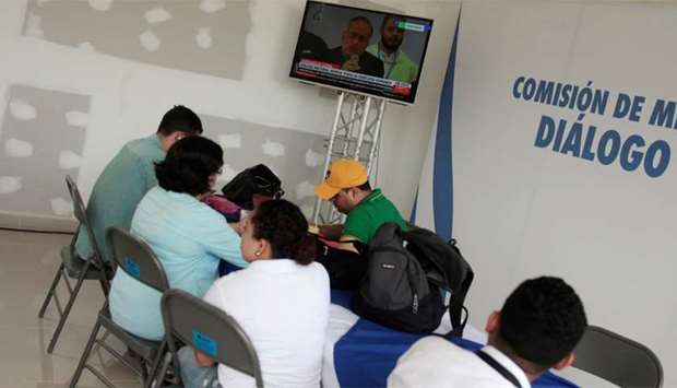 Journalists follow a live transmission of talks between representatives of Nicaragua's government and local civic groups, mediated by Catholic Church leaders, in Managua