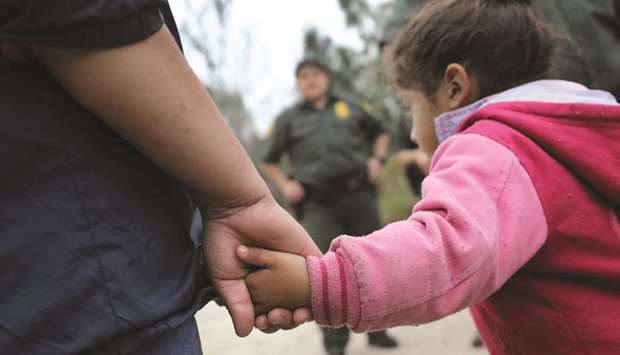 This file photo taken on January 4 last year shows a US border patrol agent taking Central American immigrants into custody near McAllen, Texas. Nearly 2,000 minors were separated from their parents or adult guardians who illegally crossed into the United States over a recent six-week period, officials said on Friday.
