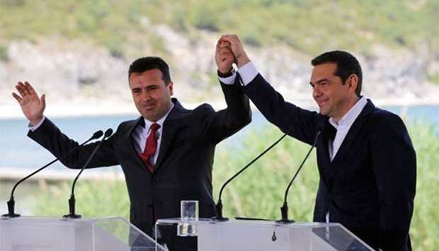 Greek Prime Minister Alexis Tsipras and Macedonian Prime Minister Zoran Zaev gesture before the signing of an accord to settle a dispute over the former Yugoslav republic's name in the village of Psarades, in Prespes, Greece, on Sunday.