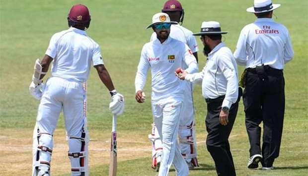 Dinesh Chandimal (centre) of Sri Lanka receives the ball from umpire Aleem Dar during day 3 of the second Test between West Indies and Sri Lanka at Daren Sammy Cricket Ground, Gros Islet, St. Lucia, on Saturday.