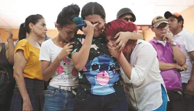 Family members and friends mourn the victims of a fire that broke out in a building in Managua, Nicaragua.