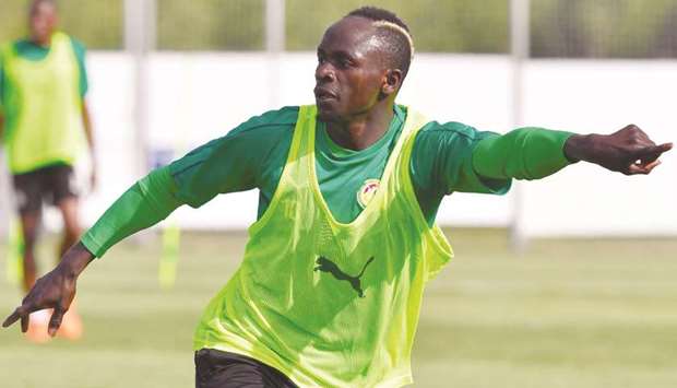 Senegalu2019s forward Sadio Mane gestures as he takes part in a training session of Senegalu2019s national football team. At right, Jules Boucher, the man who developed his talents.