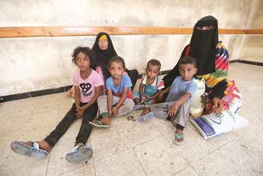 Family members sit in a classroom of a school to which they have been evacuated from a village near Hodeidah airport amid fighting between government forces and Houthi fighters in Hodeidah, Yemen.