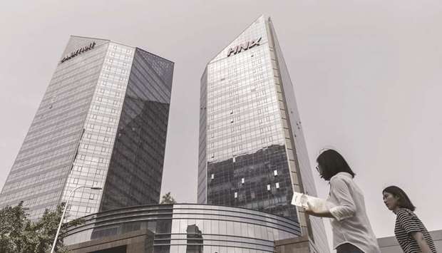 Pedestrians walk past HNA Group building in Beijing. Officials at the highest levels of government have recently determined that HNA is currently facing a liquidity issue and should be helped, according to reports.