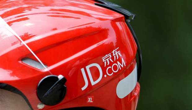 A logo of JD.com is seen on a helmet of a delivery man in Beijing, China