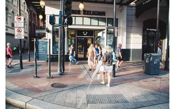 Pedestrians pass in front of a True Religion Apparel store on Canal Street in New Orleans, Louisiana. While most of the US apparel manufacturing units have moved abroad to chase lower labour costs, the country still remains home to a multibillion-dollar textile industry.