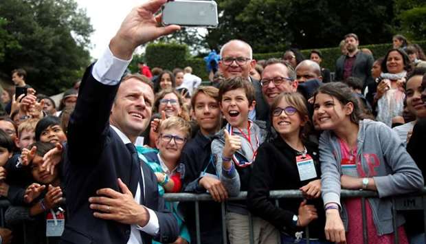 French President Emmanuel Macron makes selfie with children during a ceremony marking the 78th anniversary of late French General Charles de Gaulle's resistance call of June 18, 1940, at the Mont Valerien memorial in Suresnes, near Paris.