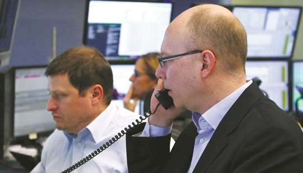 Traders are seen at the Frankfurt Stock Exchange. The DAX 30 lost 1.4% to 12,834.11 points yesterday.
