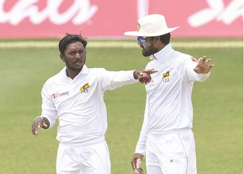 Sri Lankau2019s Akila Dananjaya and Dinesh Chandimal (right) set the field during Day 5 of the 2nd Test against West Indies at Daren Sammy Cricket Ground, Gros Islet, St. Lucia, on Monday. (AFP)