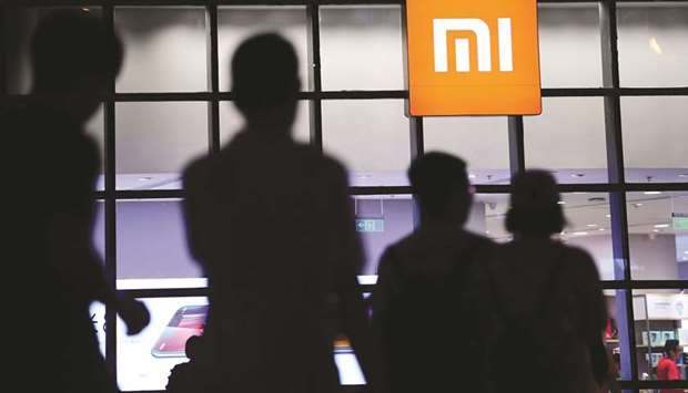 People walk past a Xiaomi store in Shenyang, Liaoning province. The Chinese smartphone maker is still expected to go ahead with its Hong Kong listing, which it plans to kick off later this week.