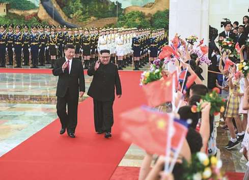 North Korean leader Kim Jong-un and Chinese President Xi Jinping waving to children after reviewing an honour guard during a welcome ceremony in Beijingu2019s Great Hall of the People.