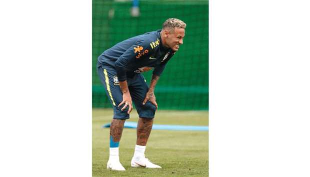Neymar grimaces after hurting his ankle during training yesterday.