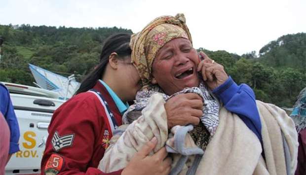 A woman cries as she finds out her family is one of missing passengers at Lake Toba ferry port in North Sumatra, after a boat overturned.