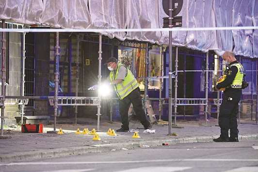 Police forensics experts are seen late on Monday at the site of the shooting in central Malmo.