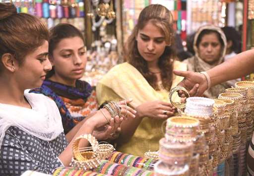 This picture taken on June 13 shows women buying bangles at a shop in Karachi ahead of the Eid holidays.