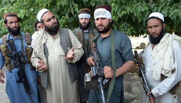 Taliban militants are seen with a resident during a ceasefire, near Jalalabad last week.