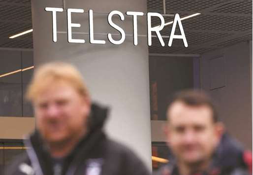 People walk past a Telstra store in Melbourneu2019s central business district. The Australian company yesterday announced plans to axe 8,000 jobs, a quarter of its  workforce, as part of a drastic new strategy to cope with an increasingly competitive industry.