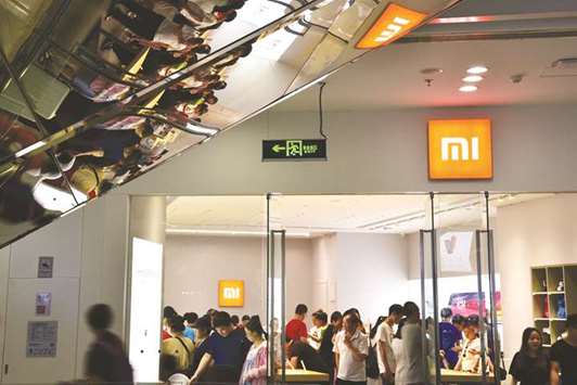 People visit a Xiaomi store in Beijing. The Chinese smartphone maker is planning to raise up to $6.1bn from a Hong Kong IPO launching this week, in what will be one of the biggest tech floats globally of recent years.