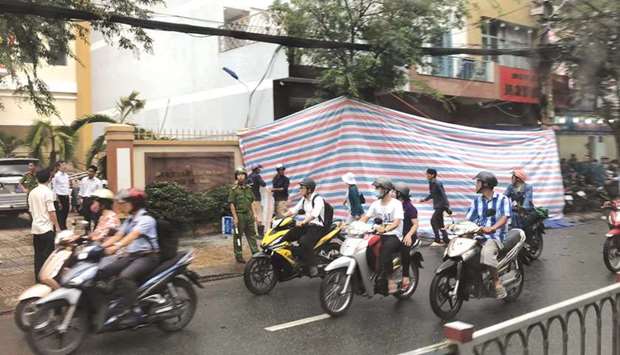 A tarpaulin covers the damaged facade of a police station in Ho Chin Minh city yesterday following an explosion that injured an officer near the site of massive protests in the city earlier this month.