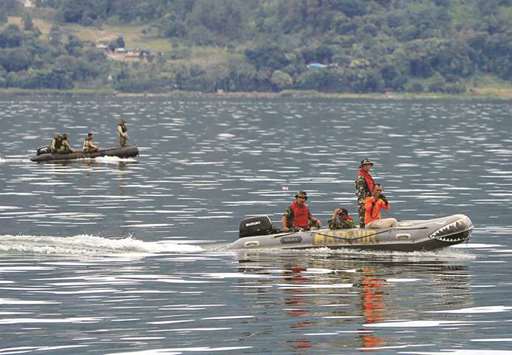 Rescue team members using rubber boats to find missing passengers from a ferry accident at the Lake Toba, in Simalungun, North Sumatra, Indonesia.