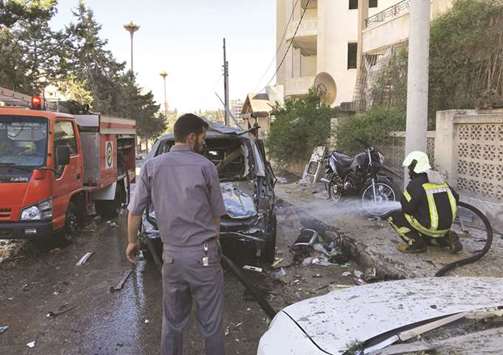 Members of the Syrian Civil Defence extinguish a destroyed car after a double explosion in the northern rebel-held city of Idlib yesterday.