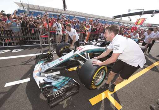 Pit crew members push the Mercedes of British driver Lewis Hamilton on the pit lane at the Circuit Paul Ricard in Le Castellet, southern France, yesterday. (AFP)