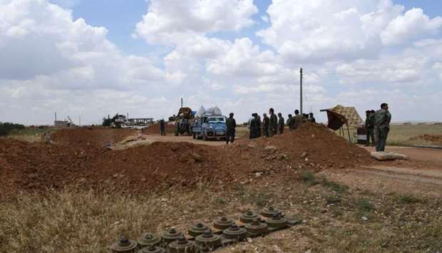 Syrian government soldiers inspect a vehicle arriving in a convoy carrying displaced people returning home to government-controlled territory at Abu al-Zuhur checkpoint in the western countryside of Idlib province.