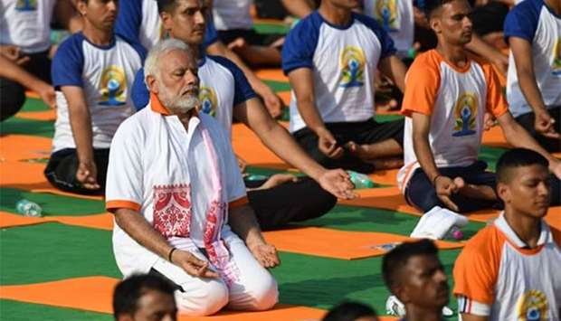 Indian Prime Minister Narendra Modi participates in a mass yoga session along with other practitioners to mark International Yoga Day at the Forest Research Institute in Dehradun on Thursday.