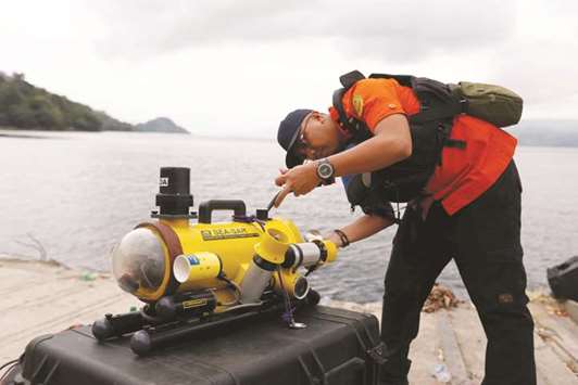 A rescue team member prepares a ROV (Remote Operated Vehicle) during search operations for the missing passengers from a ferry accident at Lake Toba at Tigaras port in Simalungun, North Sumatra.