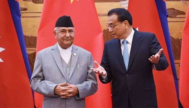 Nepal's Prime Minister K.P. Sharma Oli chats with Chinese Premier Li Keqiang during a signing ceremony at the Great Hall of the People in Beijing on Thursday.