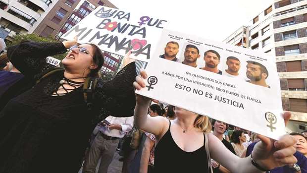 A woman holds a placard with an ironic statement which translates as u2018look how beautiful my gangu2019 as another one holds a placard displaying pictures of the five defendants during a protest in Valencia, after a court ordered the release on bail of the five, who were sentenced to nine years in prison for sexually abusing a woman at Pamplonau2019s bull-running festival in 2016.