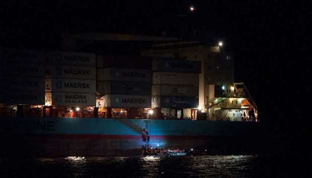 Migrants boarding a container ship of Danish shipping company Maersk Line after they were rescued from a shipwrecked vessel at sea.