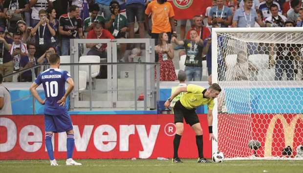 Icelandu2019s Gylfi Sigurdsson (left) waits as referee sets up the penalty shot during the match against Nigeria in Volgograd, Russia, on Friday. The missed penalty was the 12th of the tournament in the first 26 matches. (Reuters)