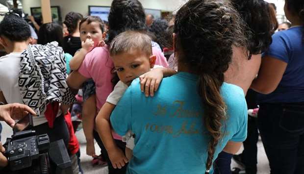 Dozens of women and their children, many fleeing poverty and violence in Honduras, Guatamala and El Salvador, arrive at a bus station following release from Customs and Border Protection yesterday in McAllen, Texas.