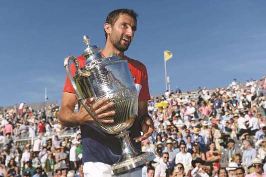 Croatiau2019s Marin Cilic celebrates with the trophy after winning the Queenu2019s Club final against Serbiau2019s Novak Djokovic in London yesterday. (Reuters)