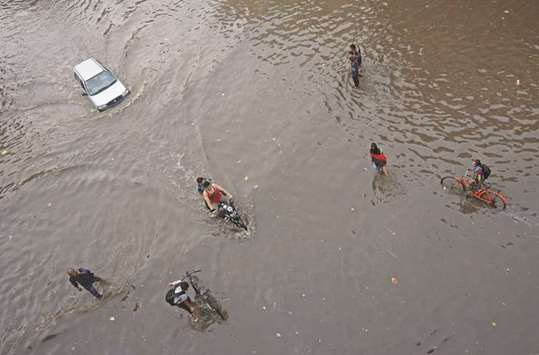 People wade through a flooded road after heavy rains in Ahmedabad yesterday.