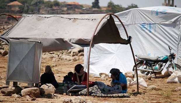 Displaced Syrian from the Daraa province fleeing shellings by pro-government forces wait in a makeshift camp in the province of Quneitra, southwestern Syria, near the border with the Israeli-occupied Golan Heights.