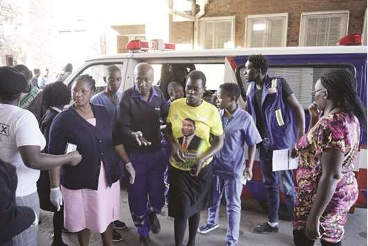 Paramedics assist an injured ZANU PF supporter disembark from an ambulance at Mpilo hospital in Bulawayo late on Saturday.